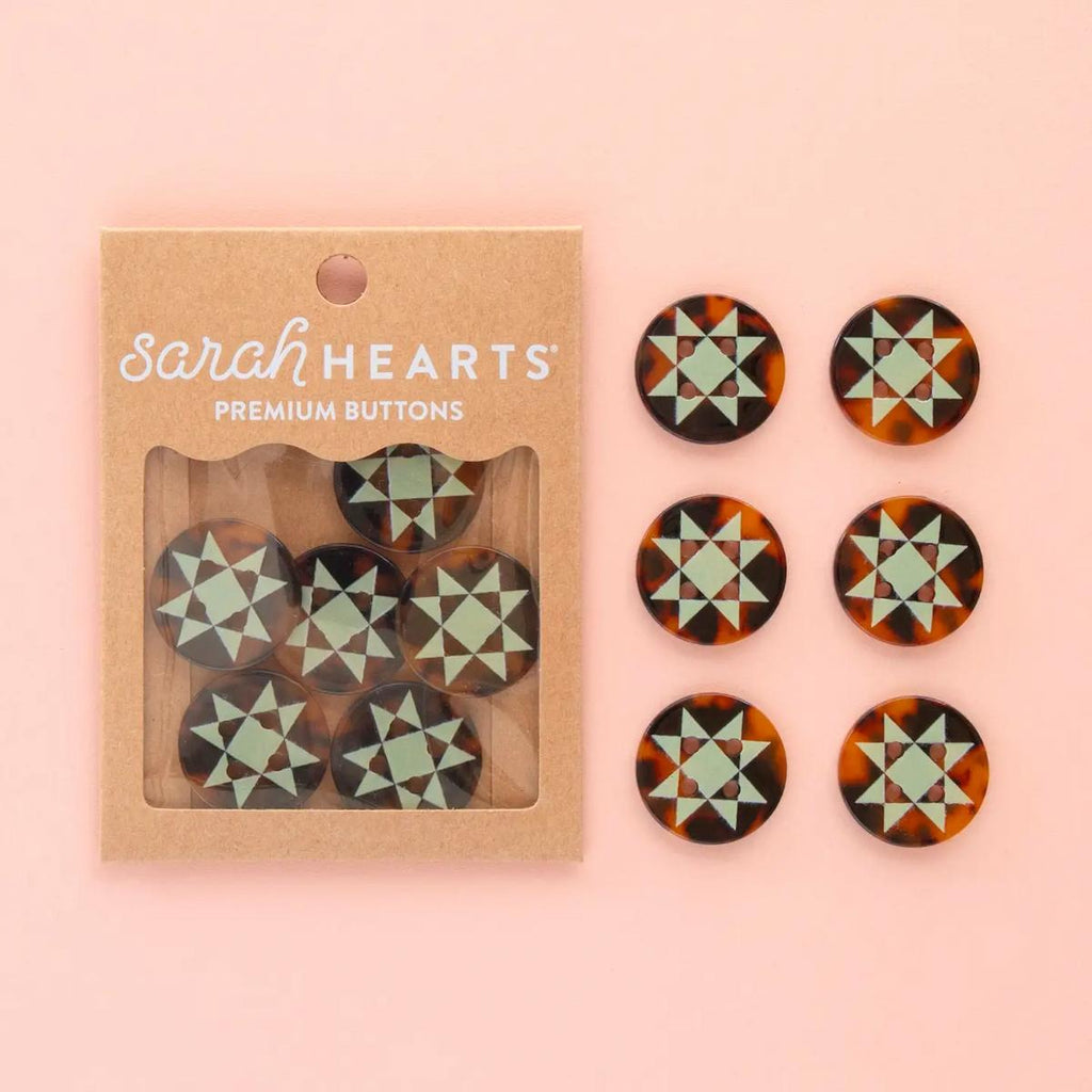 Packaged premium buttons with geometric pattern on a pink background, branded 'sarahHEARTS'.