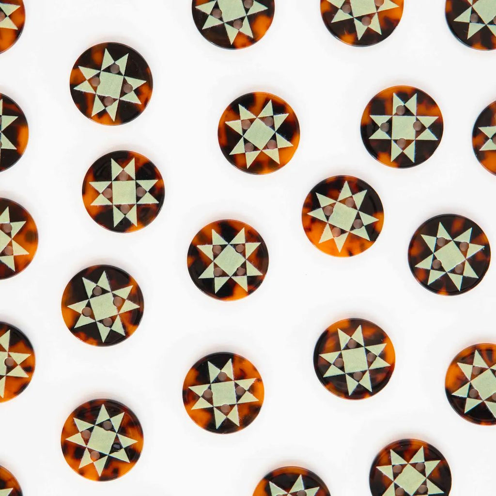 Pattern of tortoiseshell star-shaped buttons on a white background