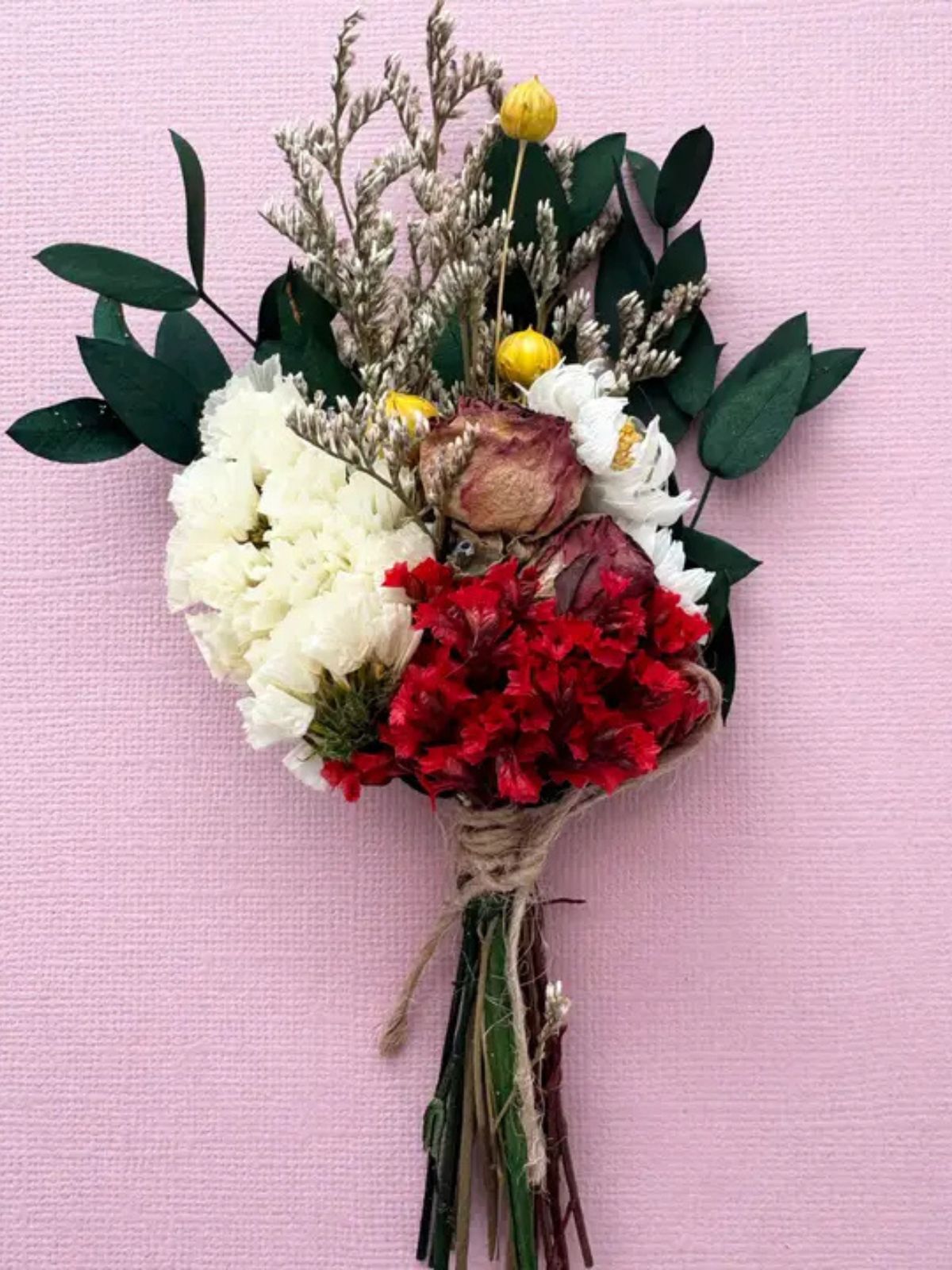 Bouquet of flowers with greenery on a pink background