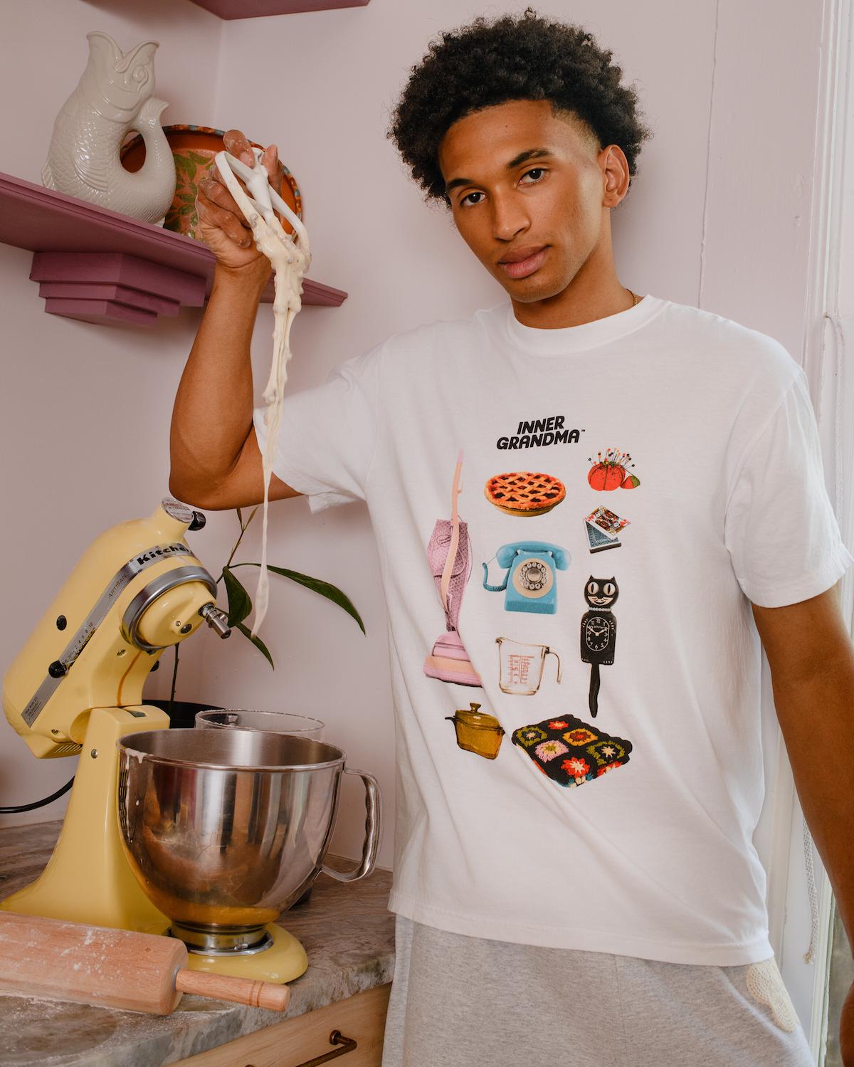Person wearing a white t-shirt with colorful graphics in a kitchen setting