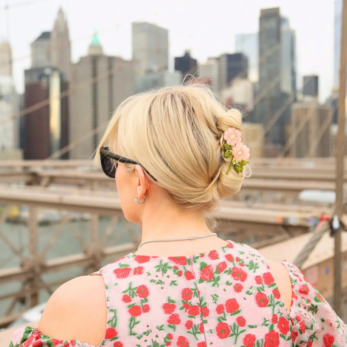 Person with floral hair accessory and floral-patterned top overlooking a city skyline