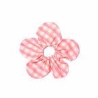 Pink and white checkered flower-shaped scrunchie on a white background