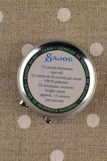 Sajou thread canister on a textured fabric background