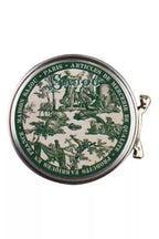Round decorative green and white tin with intricate design and on a white background