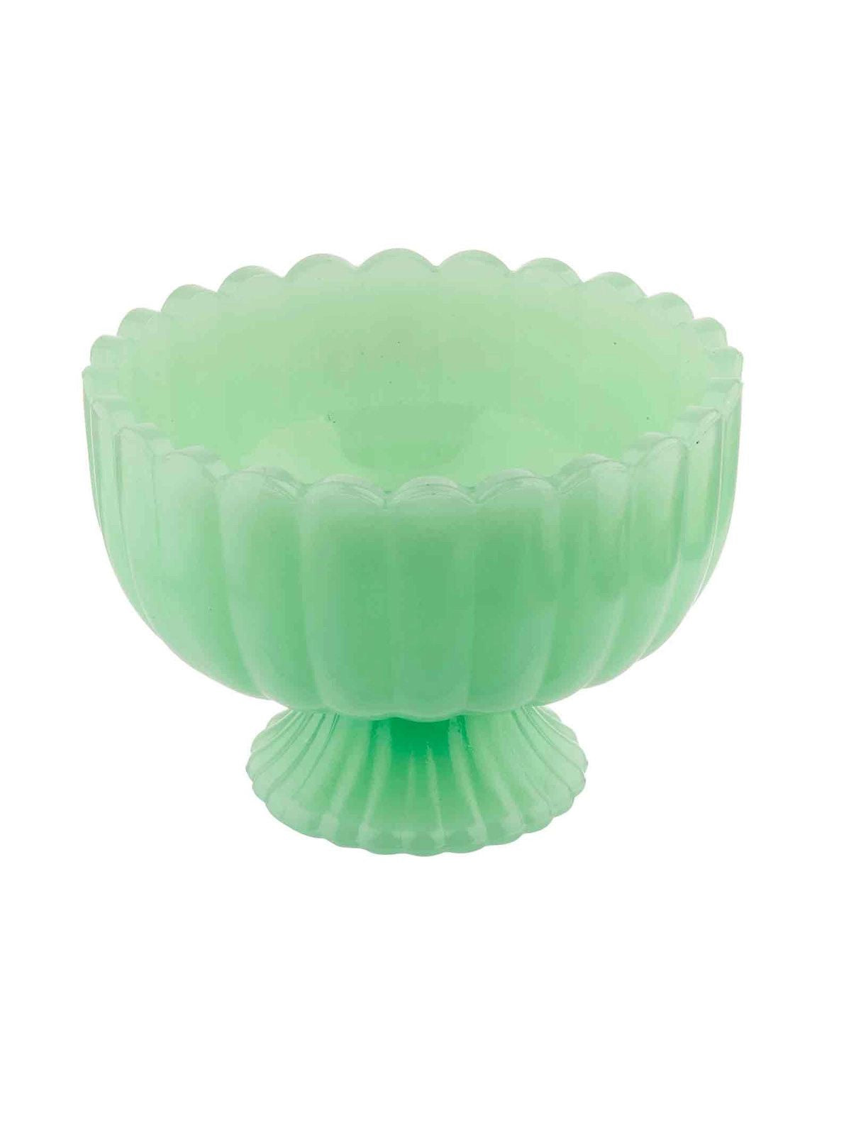 Green glass bowl with textured design on a white background