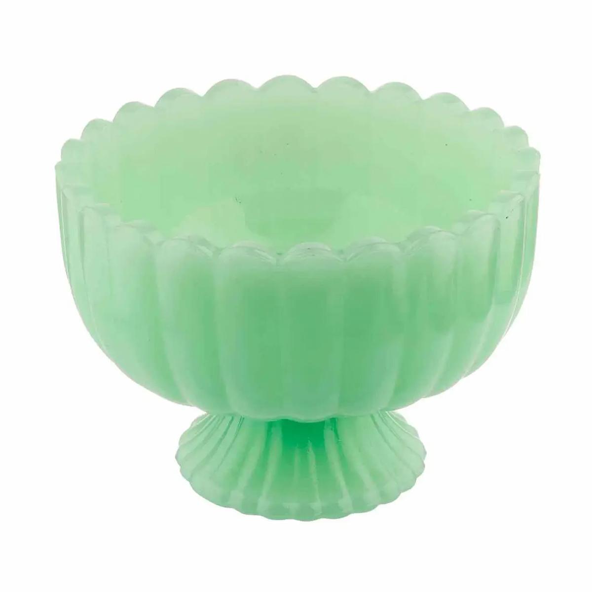 Green glass bowl with ribbed design on a white background