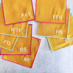 Yellow napkins with white text on a light gray surface