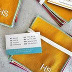 Stack of yellow fabric pads with colorful edges and a tag on a gray surface.