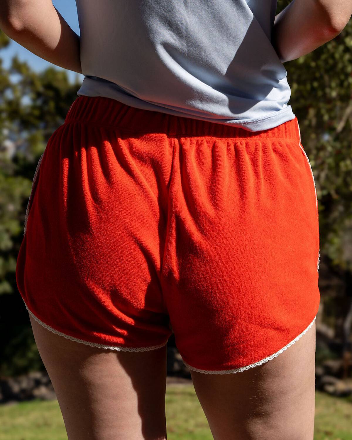 Person wearing red shorts and a light-colored top outdoors