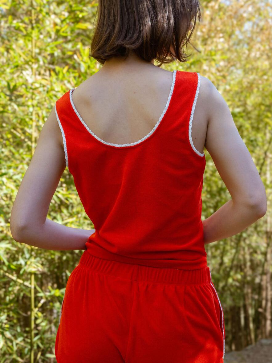 Person wearing a red outfit with a white trim in a natural setting