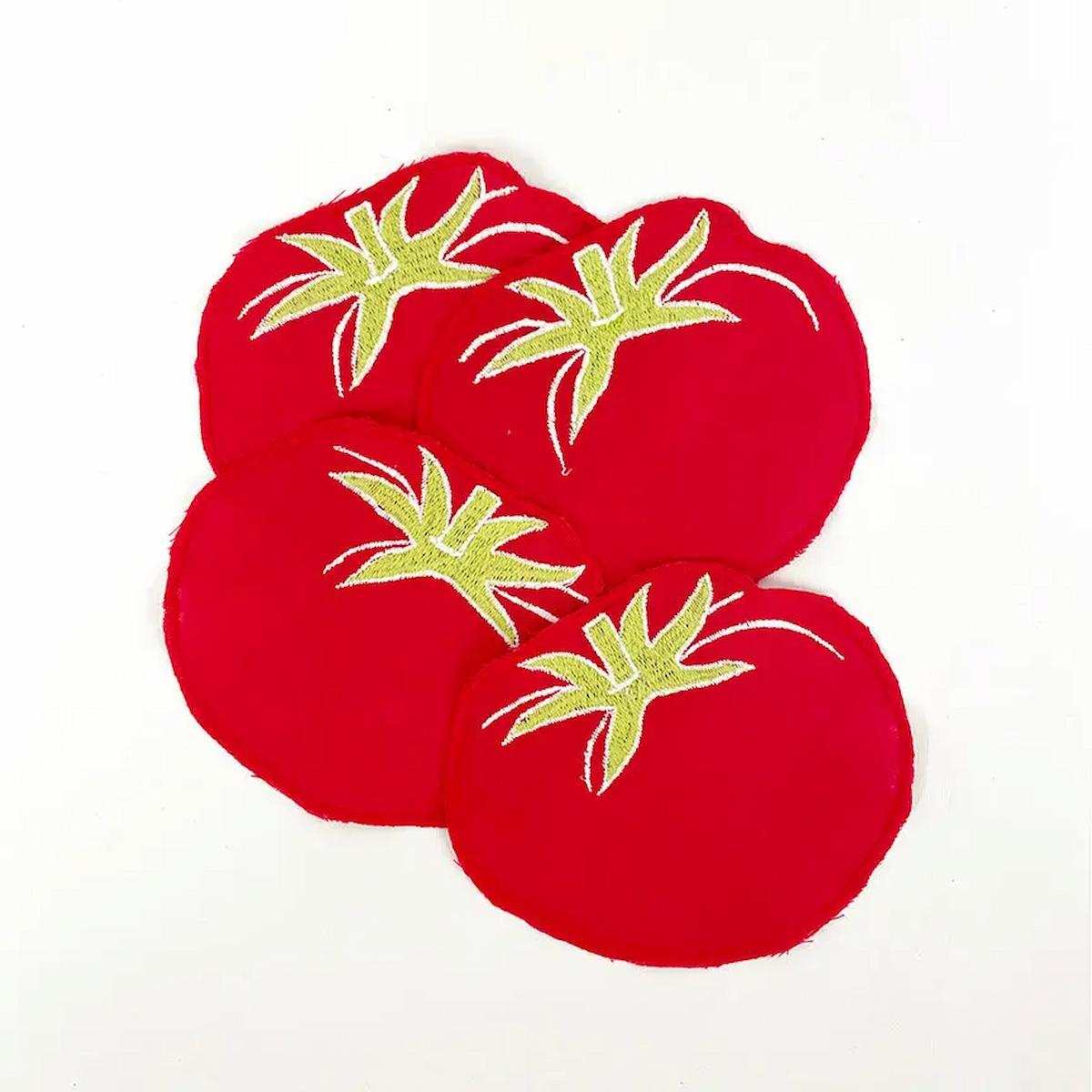 Red coasters with green leaf patterns on a white background
