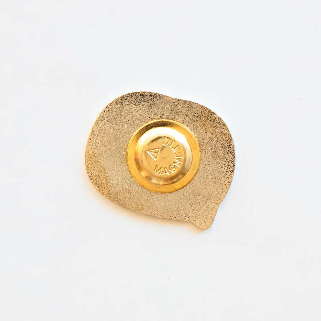 Gold decorative item with a circular design on a white background