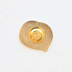Gold decorative item with a circular design on a white background