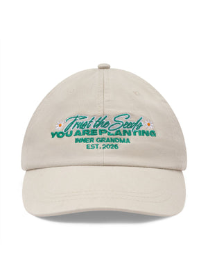 Beige cap with embroidered text on a white background