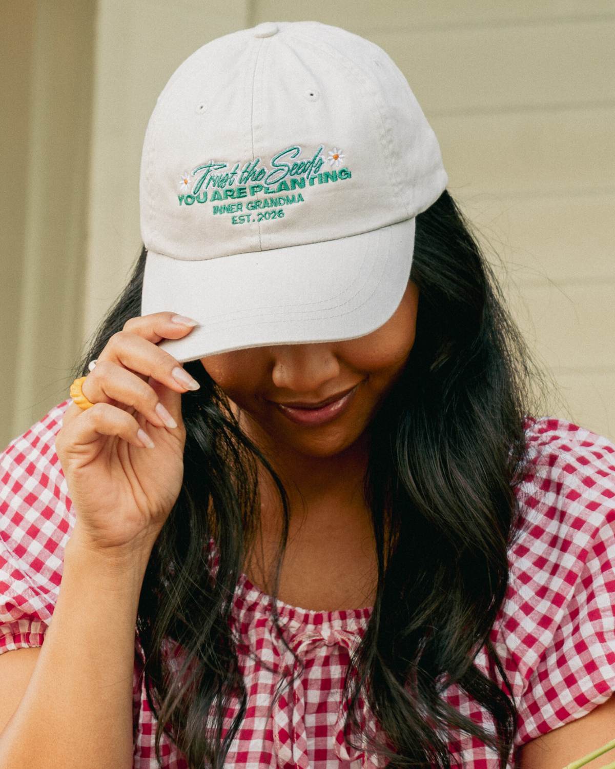 Woman wearing a white cap with text, outdoors