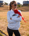 Person wearing a light blue crewneck sweatshirt with a white collar and the words 'INNER GRANDMA' printed in black, accessorized with a large red rose brooch. 