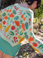 Person wearing a colorful knit cardigan with fruit pattern outdoors