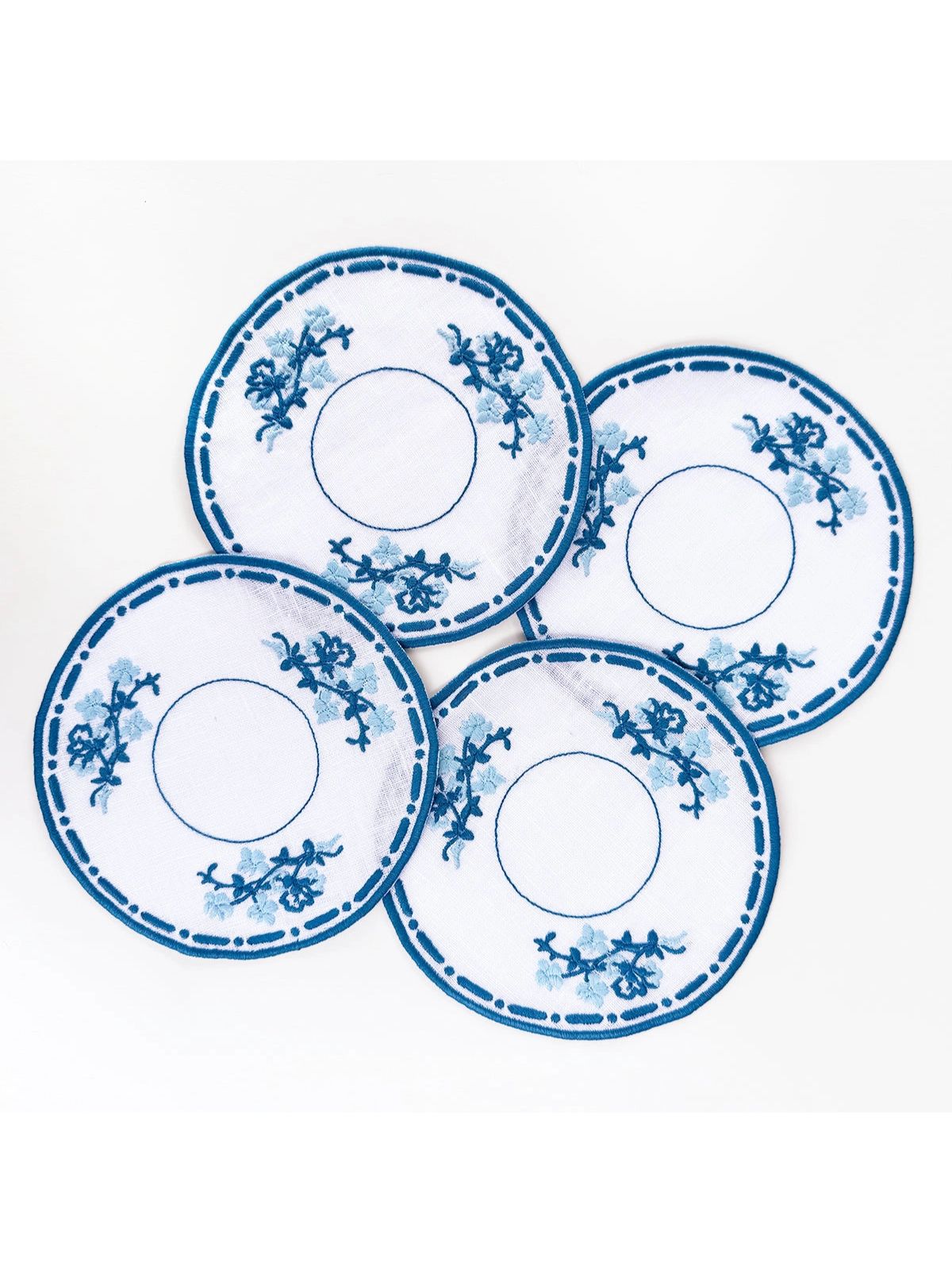Set of four blue and white decorative plates on a white background
